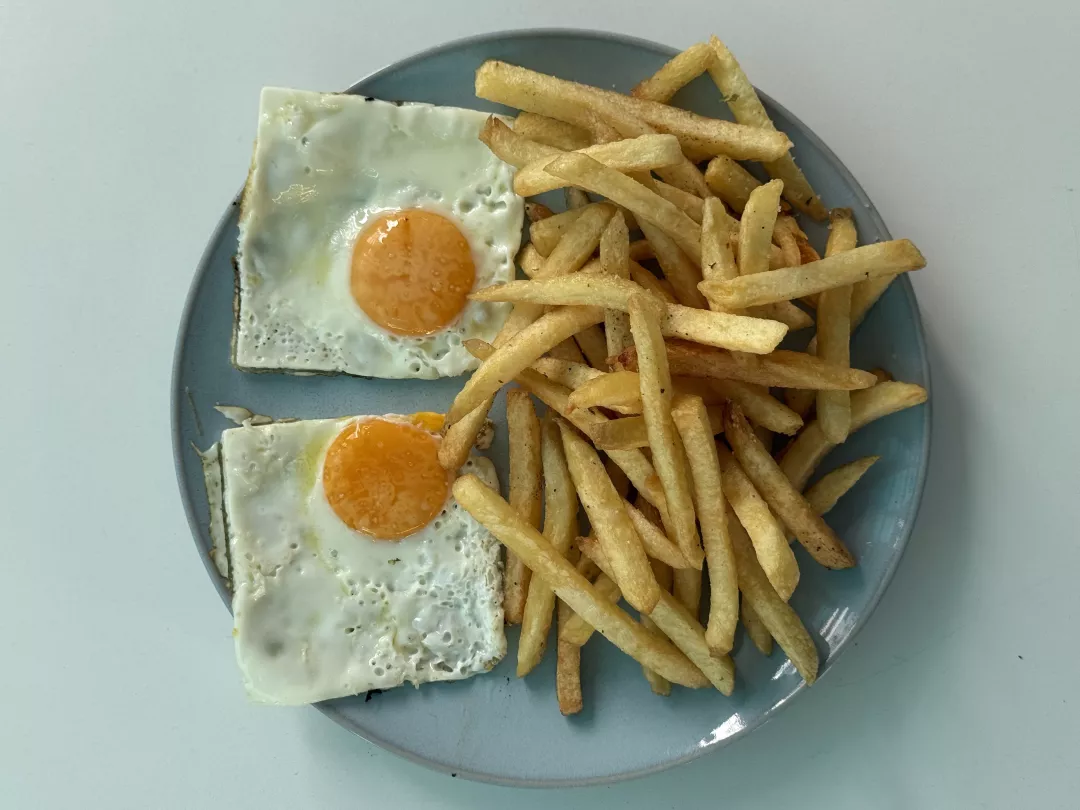 Papas fritas con huevos fritos y salchichas